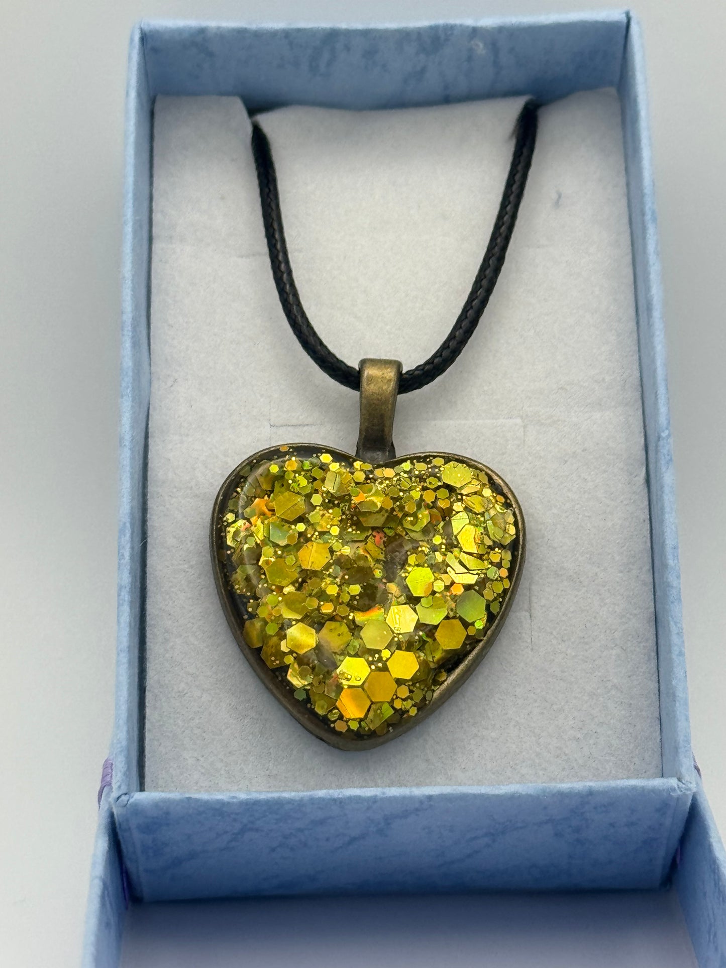 Gold resin heart with metal bezel necklace, with black waxed chain
