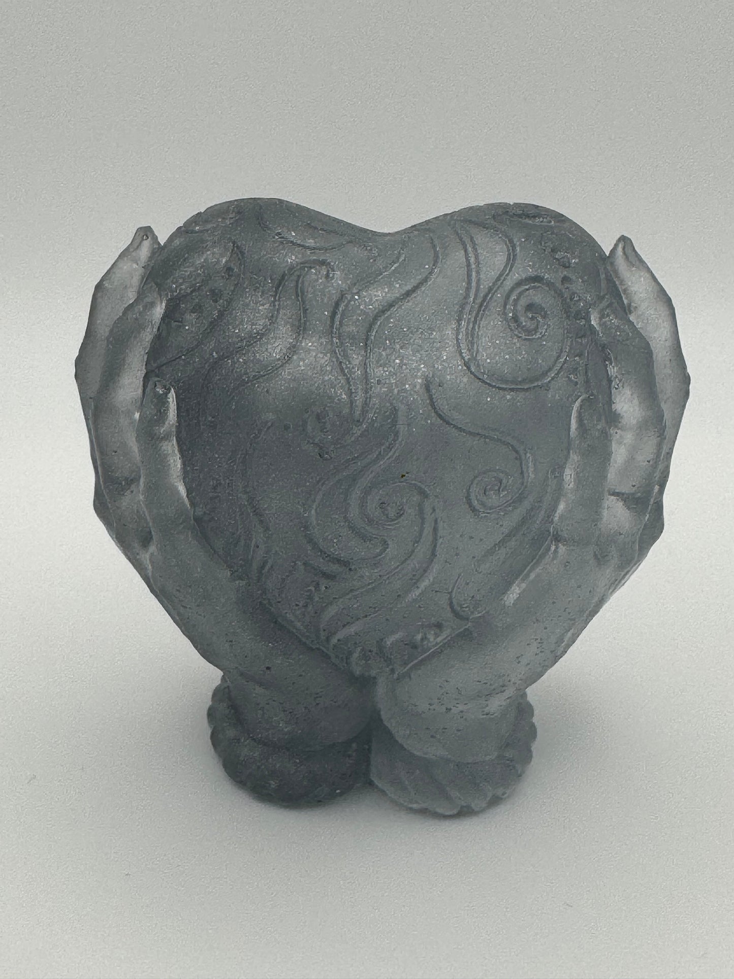 Silver resin ornament, hands holding heart