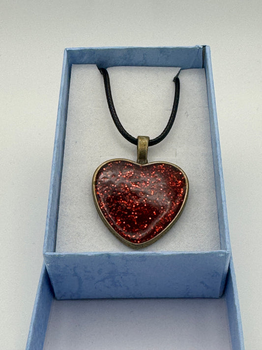 Red resin heart with metal bezel necklace, with a black waxed chain