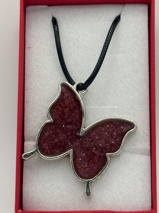 Red resin and metal butterfly necklace on black waxed chain